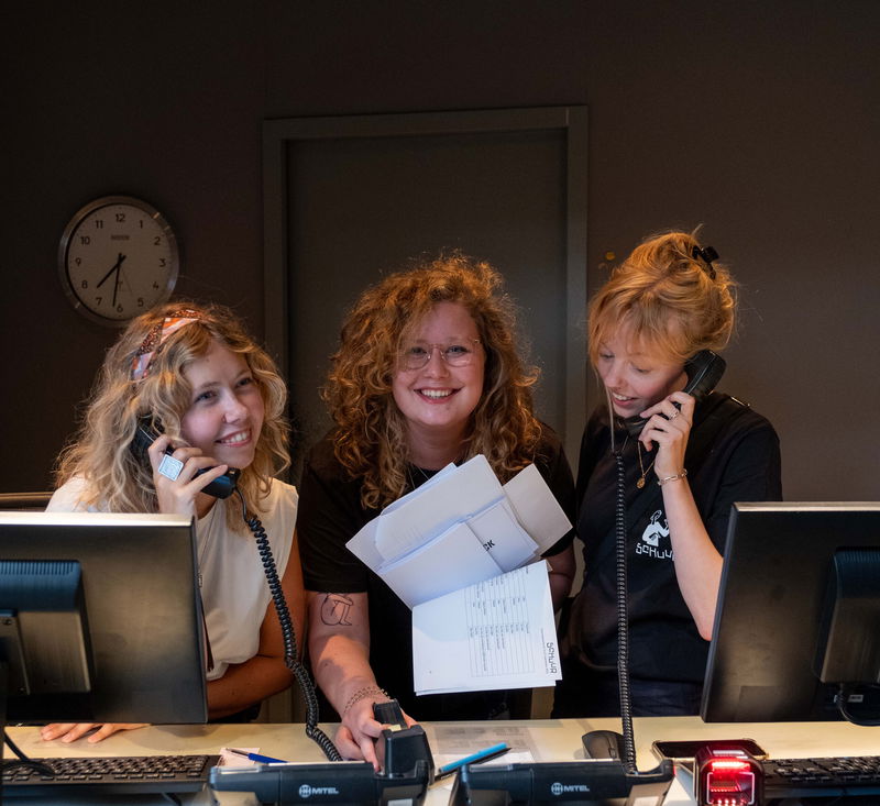 drie mensen achter balie