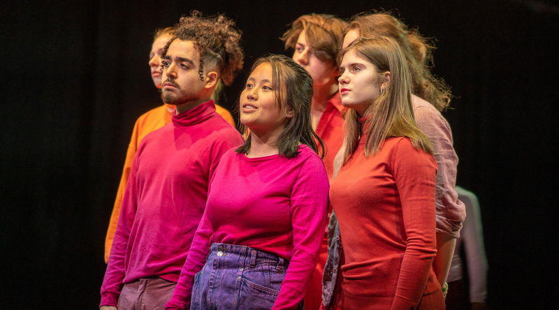 Groepje jongeren in oranje en roze kleding
