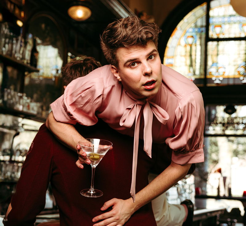Jongen over de schouder van ander persoon met coacktail in de hand